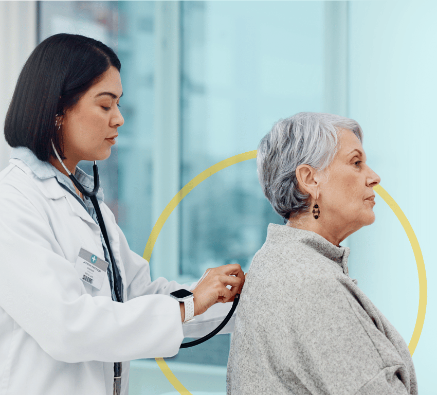 Female doctor checking the lungs of an elderly woman with a stethoscope