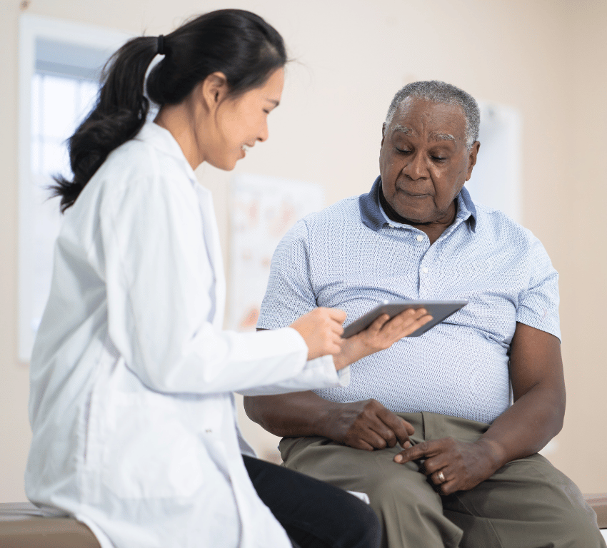 Female doctor showing elderly man health results on tablet