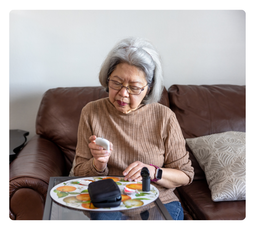 Elderly woman taking their blood sugar at home