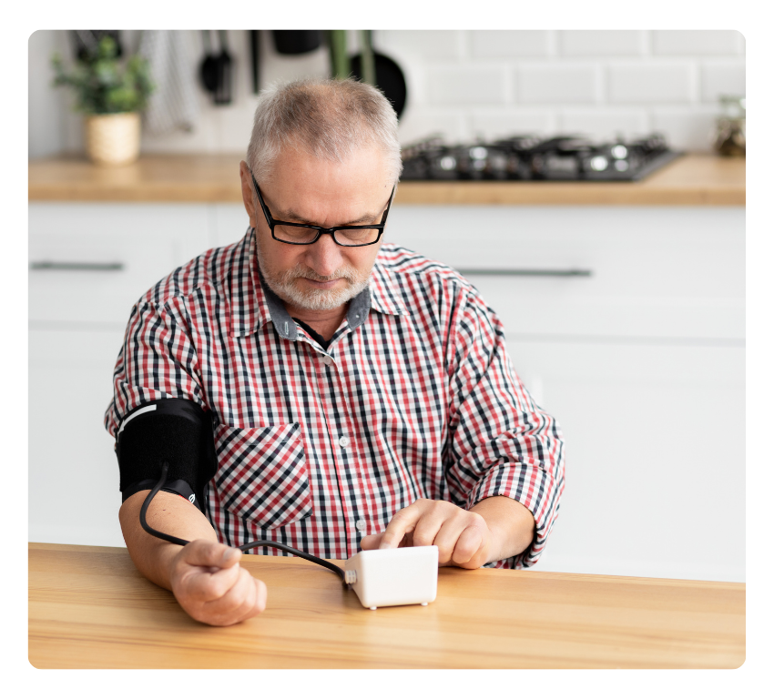 Elderly man takes his blood pressure at home 
